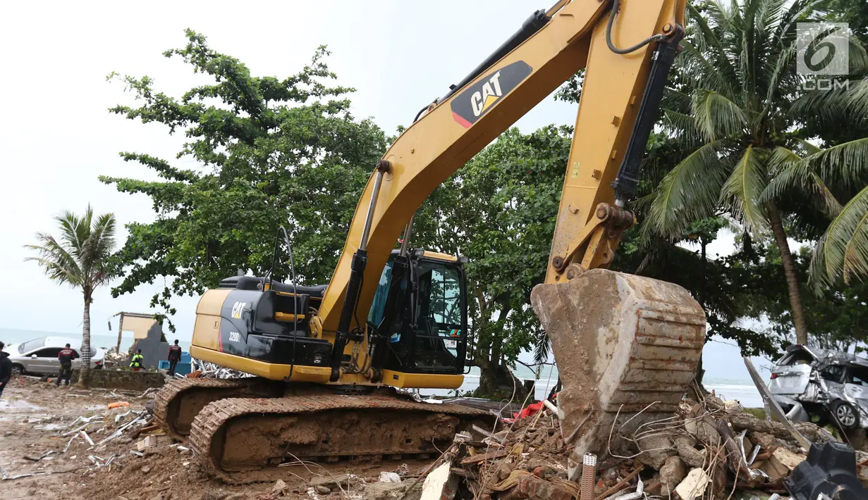 Alat berat melakukan evakuasi bangunan yang hancur akibat terjangan tsunami Selat Sunda di Carita, Banten, Selasa (25/12). Akibat tsunami yang melanda kawasan tersebut menyebakan ratusan rumah dan mobil rusak. (Liputan6.com/Angga Yuniar)