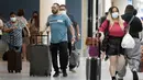 <p>Pelancong berjalan membawa barang bawaan mereka di Bandara Internasional Los Angeles, Senin (25/4/2022). Seminggu sebelumnya, seorang hakim federal di Florida menolak persyaratan untuk memakai masker di bandara dan selama penerbangan. Aturan itu, yang dirancang untuk membatasi penyebaran COVID-19, akan berakhir pada 3 Mei. (AP Photo/Marcio Jose Sanchez)</p>