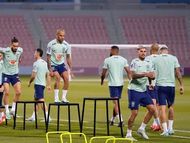 Pemain Brasil Dani Alves (tengah) dan rekan satu timnya berolahraga saat sesi latihan di Stadion Grand Hamad, Doha, Qatar, 29 November 2022. Brasil akan menghadapi Kamerun dalam pertandingan sepak bola Grup G Piala Dunia 2022 pada 2 Desember. (AP Photo/Andre Penner)