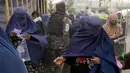<p>Seorang Taliban berjalan di antara orang-orang yang menunggu untuk menerima jatah makanan yang didistribusikan oleh kelompok bantuan kemanusiaan Korea Selatan, di Kabul, Afghanistan, Selasa (10/5/2022). Taliban pada Sabtu pekan lalu memerintahkan semua perempuan Afghanistan menutupi seluruh tubuhnya atau mengenakan burqa tradisional di depan umum. (AP Photo/Ebrahim Noroozi)</p>
