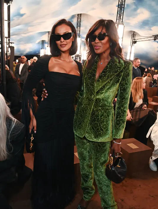Naomi Campbell tampil berani dengan setelan double breasted velvet hijau dan hand bag hitam [Burberry]