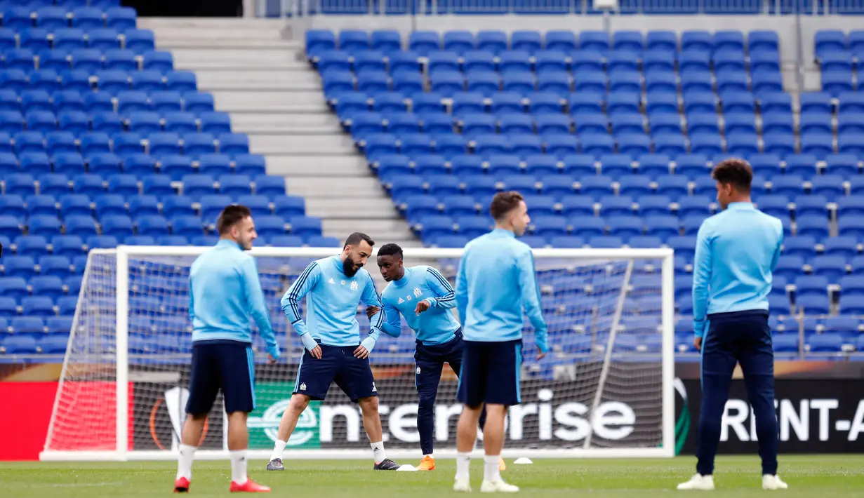 Pemain Olympique Marseille, Konstantínos Mítroglou (kedua kiri) berbincang dengan Bouna Sarr saat latihan di stadion Parc OL di Decines-Charpieu (15/5). Marseille akan melawan Atletico Madrid pada babak final Liga Europa. (AP Photo/Laurent Cipriani)