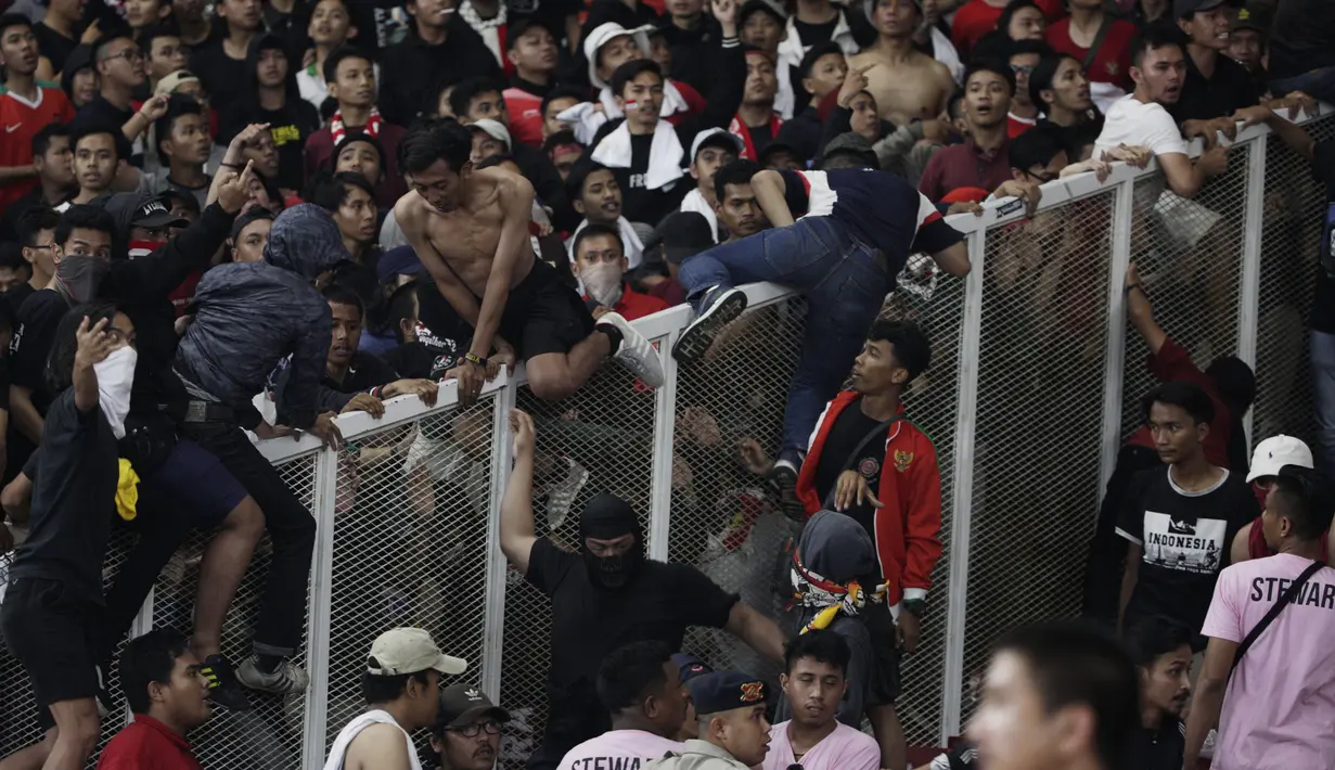 Suporter Timnas Indonesia memanjat pembatas untuk menghampiri suporter Malaysia saat laga Kualifikasi Piala Dunia 2022 di SUGBK, Jakarta, Kamis (5/9). (Bola.com/Vitalis Yogi Trisna)