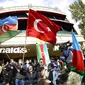 Rakyat Azerbaijan mengibarkan bendera nasional dan Turki di Baku, Azerbaijan, Selasa (10/11/2020). Armenia dan Azerbaijan mengumumkan perjanjian damai untuk menghentikan pertempuran atas wilayah Nagorno-Karabakh di Azerbaijan berdasarkan pakta yang ditandatangani dengan Rusia. (AP Photo)