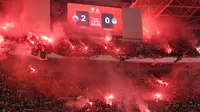 The Jakmania menyalakan Flare saat merayakan kemenangan Persija Jakarta atas PSIM Yogyakarta pada laga pekan ke-14 BRI Super League 2025/2026 di Stadion Utama Gelora Bung Karno, Jakarta, Jumat (28/11/2025) malam. (Bola.com/M Iqbal Ichsan)