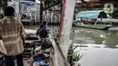 Warga menaiki perahu eretan saat menyeberangi Kali Sunter, Rawa Badak, Jakarta, Rabu (20/1/2021). Sejak pandemi COVID-19, pendapatan Hendi dan penarik perahu eretan lainnya menurun akibat anak sekolah menerapkan pembelajaran dari rumah. (merdeka.com/Iqbal S. Nugroho)