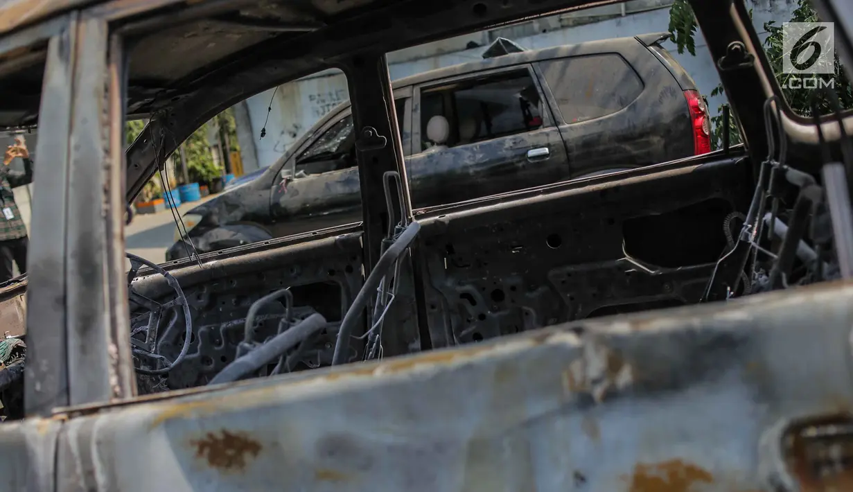 Kondisi mobil yang dibakar dan dirusak massa pasca bentrok pengunjuk rasa dan polisi di Polsek Tanah Abang, Jakarta, Selasa (1/10/2019). Mobil tersebut merupakan milik warga yang sedang diparkir. (Liputan6.com/Faizal Fanani)