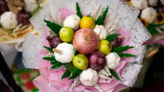 Seorang pekerja membuat karangan bunga yang terbuat dari bawang merah, tomat, dan bawang putih di pasar bunga di Manila, Filipina, Senin (13/2/2023). Buket tersebut merupakan bagian dari gimmick Hari Kasih Sayang oleh seorang pemilik toko bunga yang mengatakan lebih praktis daripada memberi bunga karena Anda bisa memasaknya setelah itu. (AP Photo/Aaron Favila)