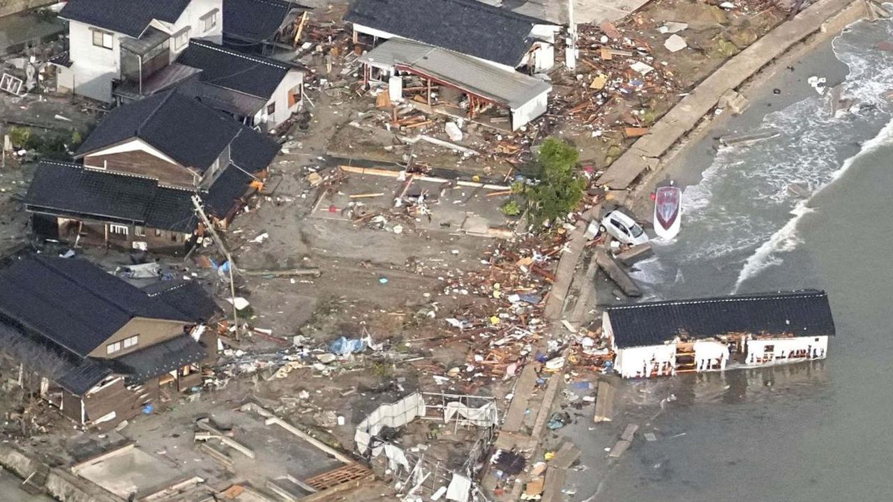 Pemandangan sebuah mobil dan rumah hanyut setelah terjadi gempa di pesisir Kota Noto, Prefektur Ishikawa, Jepang, pada Senin (1/1/2024). Gempa besar berkekuatan 7,5 magnitudo yang mengguncang Jepang telah memicu terjadinya gelombang tsunami.