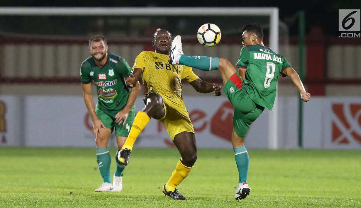 Pemain depan Bhayangkara FC, Herman Dzumafo (tengah) berebut bola dengan gelandang PSMS, Abdul Aziz pada lanjutan Go-Jek Liga 1 Indonesia bersama Bukalapak, Stadion PTIK, Jakarta, Jumat (3/8). Bhayangkara FC unggul 3-1. (Liputan6.com/Helmi Fithriansyah)