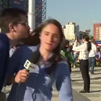 Seorang reporter Brazil Julia Guimarães mencoba menghindari ciuman dari seorang supperter Piala Dunia yang tak dikenalnya. (Sumber Foto: The Sun)