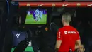 Wasit Javier Iglesias Villanueva memeriksa rekaman VAR sebelum memutuskan memberi hadiah tendangan penalti kepada Barcelona saat menghadapi Mallorca pada laga pekan ke-28 LaLiga 2023/2024 yang berlangsung di Olimpic Lluis Companys Stadium, Barcelona, Sabtu (9/3/2024) dini hari WIB. (AP Photo/Joan Monfort)