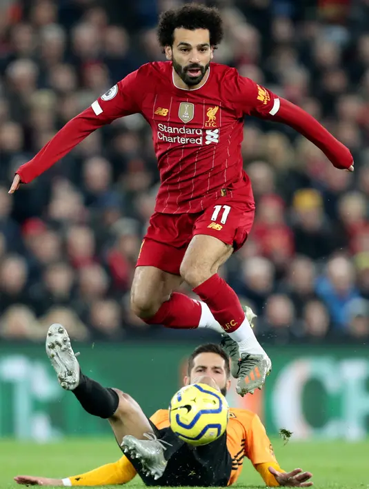 Pemain Wolvehampton Wanderers,  Joao Moutinho berebut bola dengan penyerang Liverpool, Mohamed Salah pada pekan ke-20 Liga Inggris 2019-2020 di Anfield, Minggu (29/12/2019). Liverpool semakin perkasa di Premier League setelah menang 1-0 atas Wolverhampton. (AP/Jon Super)