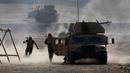 Tentara Irak berlari berlindung dibalik kendaraan militer setelah menembakan RPG saat bertempur melawan ISIS di Al-Qasar, Tenggara Mosul, Irak, (28/11). (REUTERS/Goran Tomasevic)
