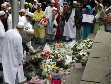 Sejumlah muslim meletakkan karangan bunga di Potters Field Park, London, Senin (5/6). Mereka mengenang dan mendoakan para korban serangan teror di London Bridge dan Borough Market yang menewaskan 7 orang dan melukai puluhan lainnya. (AP Photo/Tim Ireland)