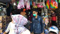 Warga memilih mainan tanpa menjaga jarak di Pasar Gembrong, Jakarta Timur, Minggu (31/5/2020). Meski penerapan masa Pembatasan Sosial Berskala Besar (PSBB) di Jakarta masih berlaku, namun pasar yang khusus menjual pernak-pernik mainan anak ini kembali dipadati warga. (Liputan6.com/Immanuel Antonius)