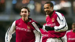 Thierry Henry dan Robert Pires - Duet legendaris Arsenal ini merupakan salah satu kunci kejayaan The Gunners era Arsene Wenger. Kala itu keduanya mampu 29 gol untuk klub Meriam London. (AFP/Adrian Dennis)