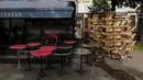 Seorang pekerja membersihkan teras restorannya, di Paris, Senin (17/5/2021). Teras luar kafe dan restoran Prancis akan diizinkan untuk dibuka kembali pada 19 Mei bersama dengan museum, bioskop, teater, dan ruang konser dalam kondisi tertentu. (AP Photo/Thibault Camus)