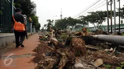 Warga melintasi jalur pedestrian di Jalan Gerbang Pemuda Senayan, Jakarta, Selasa (12/7/2016). Pasca pengosongan lapak pedagang tanaman pertengahan Mei lalu, hingga kini jalur pejalan kaki di kawasan ini masih berantakan. (Liputan6.com/Helmi Fithriansyah)