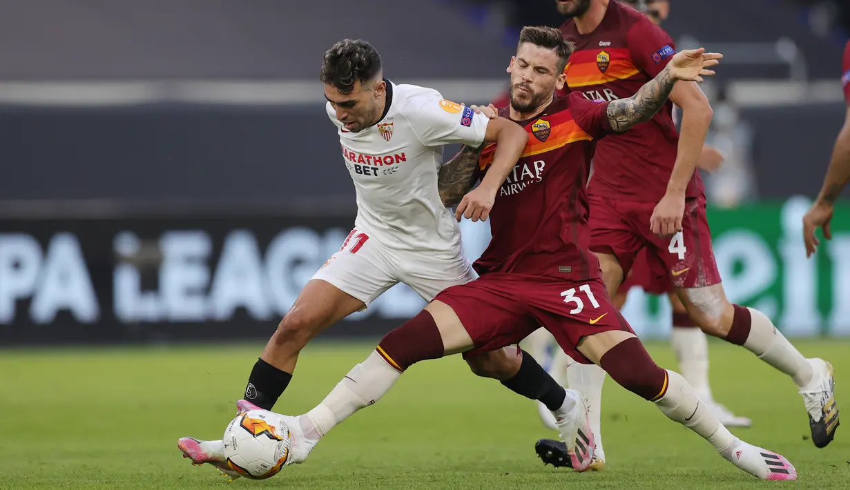 Penyerang Sevilla, Munir El Haddadi, berebut bola dengan penyerang AS Roma, Carles Perez, dalam laga babak 16 besar Liga Europa 2019/2020 di MSV-Arena, Jerman, Jumat (7/8/2020) dini hari WIB. Sevilla menang 2-0 atas AS Roma. (AFP/Friedemann Vogel/pool)