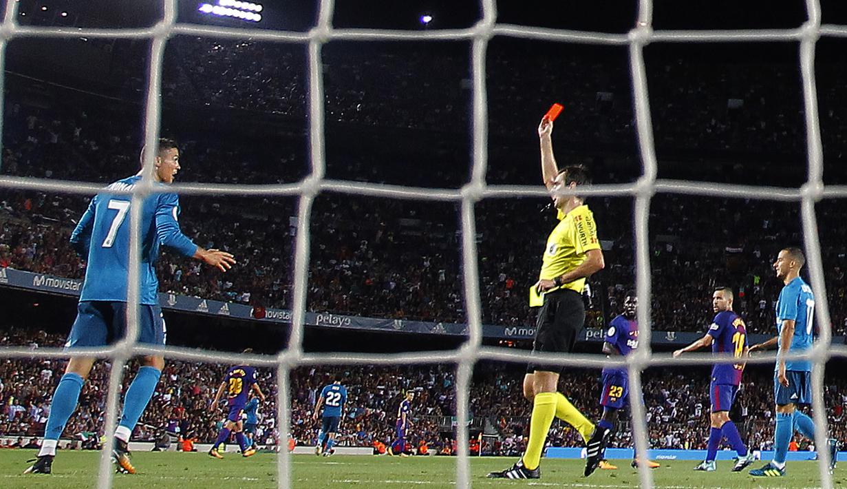 Wasit Ricardo de Burgos memberikan kartu merah kepada Cristiano Ronaldo saat melawan di Barcelona Camp Nou stadium, (13/82017). Akibat kartu merah tersebut Ronaldo dilarang bermain lima laga. (AP/Manu Fernandez)