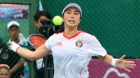Petenis putri Indonesia, Aldila Sutjiadi berusaha mengembalikan bola ke arah petenis Thailand, Aunchisa Chanta pada pertandingan final tenis beregu putri SEA Games 2023 di Tennis Arena, Morodoc Techo National Stadium, Phnom Penh, Kamboja, Selasa (9/5/2023). Indonesia sempat tertinggal di partai pertama namun sukses menyamakan kedudukan saat partai kedua. Pasangan Aldila dan Jessy kemudian sukses menyegel kemenangan partai ketiga sekaligus memberikan emas ke-24 untuk Indonesia. (Bola.com/Abdul Aziz)