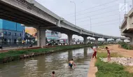 Anak-anak bermain dan berenang di Sungai Kalimalang, Jakarta Timur, Jumat (5/7/2019). Tingginya suhu udara Ibu Kota akibat musim kemarau menyebabkan anak-anak tersebut berenang di Sungai Kalimalang meski dengan kondisi seadanya. (Liputan6.com/Immanuel Antonius)