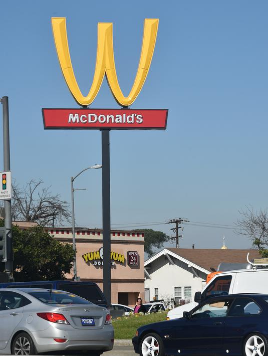Plang iklan restoran cepat saji McDonald's dengan logo terbalik di Lynwood, California (8/3). Huruf W tersebut merupakan inisial untuk women atau wanita. (AFP Photo/Frederic J. Brown)