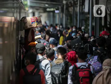 Pemudik menunggu giliran untuk naik ke dalam kereta tujuan mereka di Stasiun Pasar Senen, Jakarta, Selasa (26/4/2022). Sepekan menjelang Lebaran, lonjakan jumlah penumpang kereta api sudah mulai terlihat pada Selasa siang ini, dan diperkirakan akan terus bertambah hingga 30 April atau H-2 Idul Fitri. (Liputan6.com/Faizal Fanani)