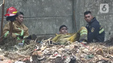 Petugas pemadam kebakaran beristirahat usai memadamkan api di lapak ban bekas, Desa Bojong Nangka, Gunung Putri, Bogor, Kamis (22/4/2021). Banyaknya bahan yang mudah terbakar dan sumber api yang berasal dari bawah tumpukan ban membuat  api di lokasi belum juga padam. (Liputan6.com/Herman Zakharia)