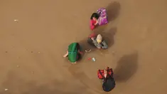 Warga menembus banjir yang merendam kabupaten Bandung, Jawa Barat, Minggu (13/3). Kawasan Bandung Selatan kembali dilanda banjir akibat luapan Sungai Citarum dan membuat lebih dari 3000 jiwa mengungsi. (Timur Matahari/AFP)
