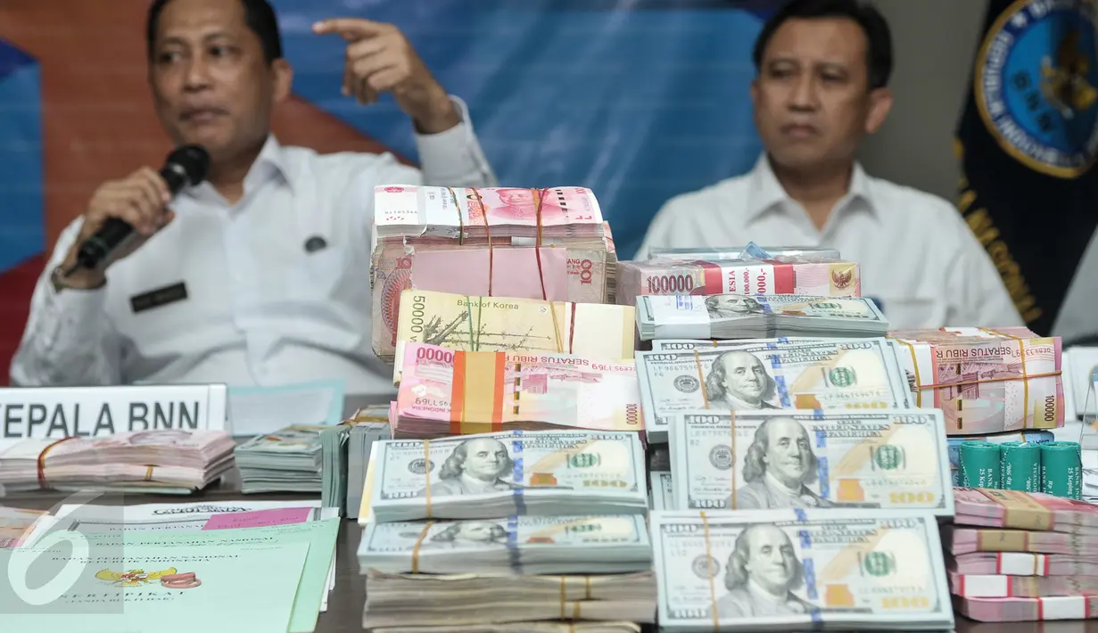 Barang bukti mata uang asing dan lokal hasil kejahatan narkotika di Gedung BNN, Jakarta, Selasa (25/10). BNN mengungkap Tindak Pidana Pencucian Uang (TPPU) selama setahun terakhir senilai Rp2,7 triliun. (Liputan6.com/Yoppy Renato)