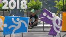 Pekerja beristirahat sejenak dekat logo cabang olahraga Asian Games 2018 di Bundaran HI, Jakarta, (17/8/2017), Asian Games mengambil tema Energy Of Asia dan akan dibuka oleh Presiden Republik Indonesia Joko Widodo. (Bola.com/Nicklas Hanoatubun)