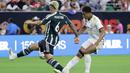 Pemain Real Madrid, Jude Bellingham (kanan), menendang bola dan dihadang pemain MU, Lisandro Martinez (kiri), dalam pertandingan pramusim Soccer Champions Tour 2023 yang berlangsung di NRG Stadium, Houston, Kamis (27/7/23). Kedua pemain tersebut terlibat keributan di menit ke-42 setelah Martinez melakukan pelanggaran keras berupa tekel dengan kedua kakinya terhadap Jude Bellingham. (AP Photo/Michael Wyke)
