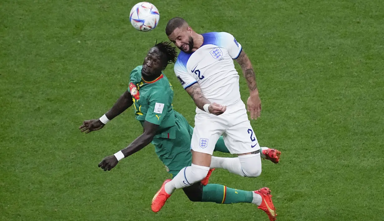Bek Senegal Moussa Ndiaye berebut bola dengan bek Inggris Kyle Walker pada laga babak 16 besar Piala Dunia 2022 di Al Bayt Stadium, Senin (5/12/2022) dini hari WIB.  Inggris lebih mendominasi penguasaan bola, tetapi masih belum banyak ancaman berbahaya yang diperlihatkan tim asuhan Gareth Southgate. (AP Photo/Darko Bandic)