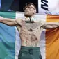 Petarung MMA, Conor McGregor, berpose dengan bendera negaranya saat sesi timbang berat badan di Las Vegas, Jumat (25/8/2017). Keduanya akan bertarung pada Minggu (27/6/2017) di T-Mobile Arena, Las Vegas, Amerika Serikat. (AP/John Locher)