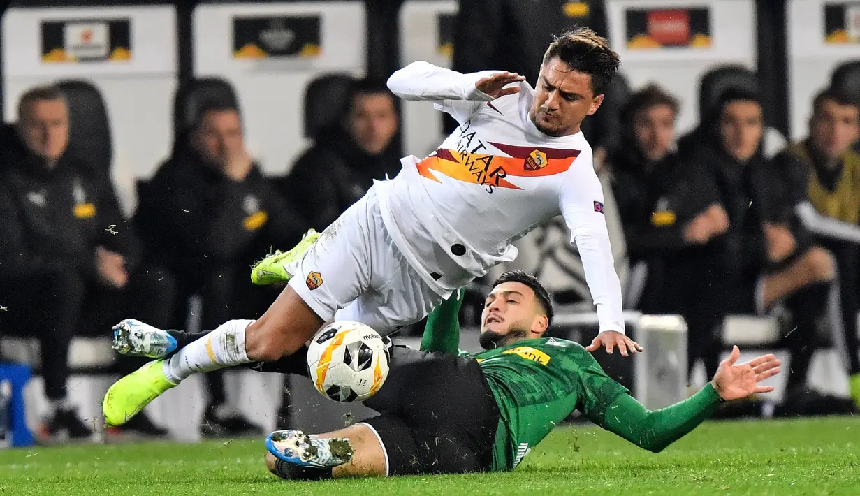 Winger muda AS Roma, Cengiz Under berebut bola dengan pemain Borussia Monchengladbach, Ramy Bensebaini dalam laga matchday keempat fase grup Liga Europa 2019-2020 di Stadion IM Borussia-Park, Kamis (7/11/2019). AS Roma takluk dari tim tuan rumah dengan skor 2-1. (AP/Martin Meissner)