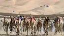 Sejumlah unta berpacu saat mengikuti lomba balap Liwa 2018 Moreeb Dune Festival di gurun Liwa, Abu Dhabi (26/12). Sosok-sosok mungil yang terlihat duduk di punggung unta sambil memecutkan tongkat kini adalah robot. (AFP Photo/Karim Sahib)