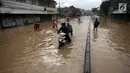 Seorang pengendara motor melintasi banjir di Jalan Jatinegara Barat, Jakarta Timur, Selasa (6/2). Beberapa kendaraan yang nekat melintas akhirnya terpaksa didorong karena mogok. (Liputan6.com/Arya Manggala)