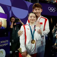 Saat Huang Yaqiong mendapat emas dari cabang olahraga badminton nomor mix double, ia pun mengenakan setelan jaket dan celana tim China senada dengan calon suaminya. [@hyq28]