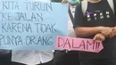 Massa dari Forum Komunikasi Nakes dan Non-Nakes Indonesia (FKHN Indonesia) membentangkan poster saat menggelar aksi di kawasan Patung Kuda, Jakarta Pusat, Kamis (22/9/2022). Sejumlah petugas gabungan berjaga di sekitar lokasi aksi dan awat berduri serta road barrier juga telah disiagakan. (Liputan6.com/Herman Zakharia)