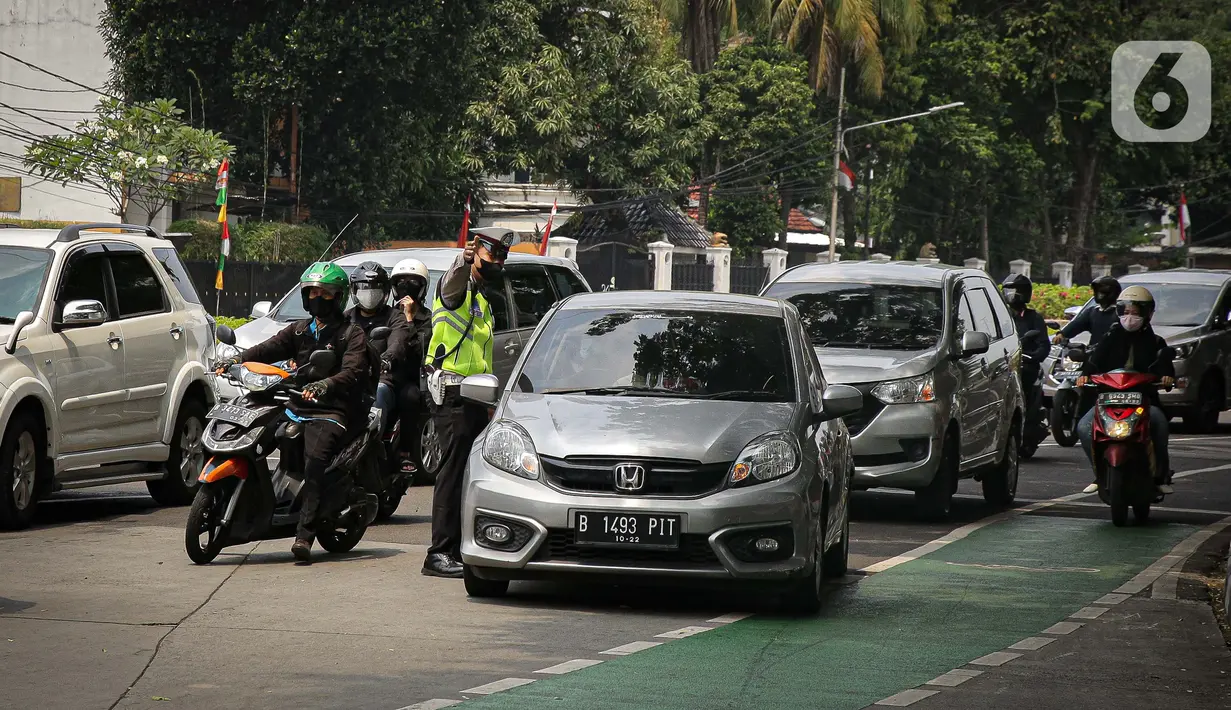 Petugas polisi mengarahkan kendaraan berplat nomor ganjil di titik pemeriksaan ganjil-genap Bundaran Senayan, Jakarta, Kamis, (26/8/2021). Mulai 26 sampai 30 Agustus, ganjil genap hanya berlaku di 3 ruas jalan Jakarta yakni, Jalan Sudirman, MH Thamrin, dan HR Rasuna Said (Liputan6.com/Faizal Fanani)
