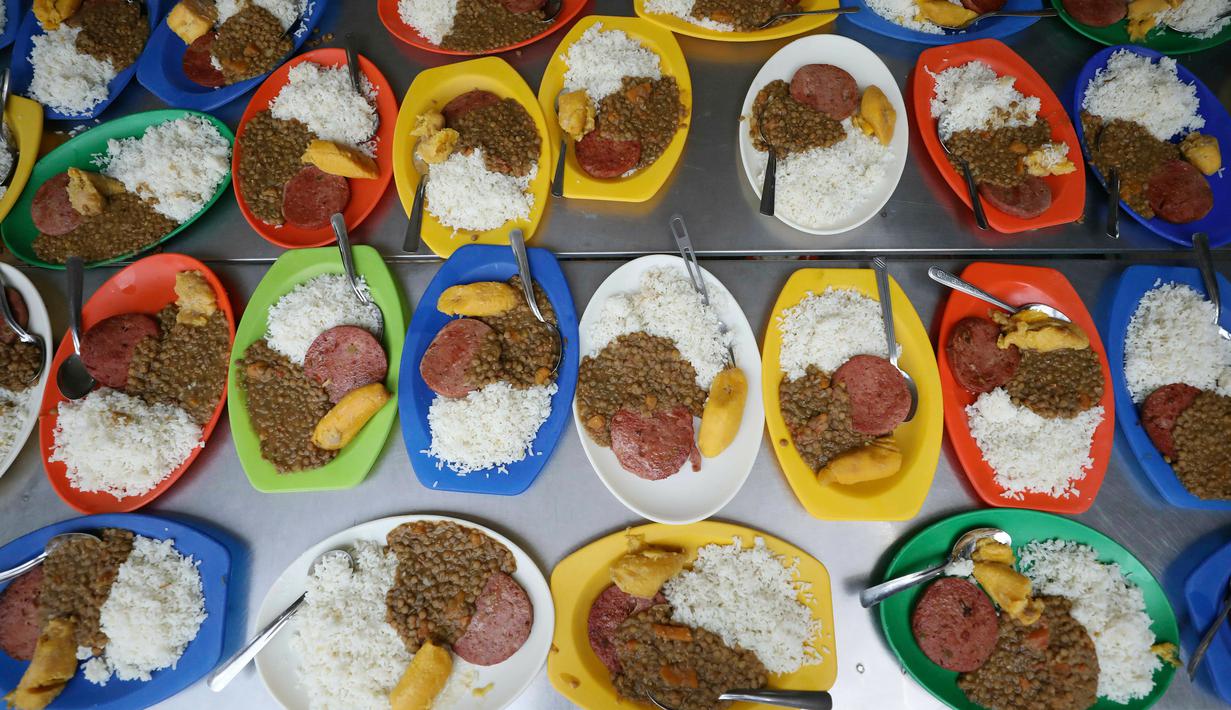 Makanan untuk pengungsi Venezuela disiapkan di tempat penampungan Divina Providencia, La Parada, Cucuta, Kolombia, Senin (18/2). Sebagian besar makanan disiapkan untuk imigran Venezuela. (AP Photo/Fernando Vergara)