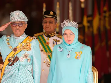 Raja Malaysia Sultan Abdullah Sultan Ahmad Shah (kiri) memberi hormat di samping Ratu Tunku Azizah Aminah Maimunah dan PM Mahathir Mohamad saat upacara pelantikannya di Istana Nasional, Kuala Lumpur, Malaysia, Kamis (31/1). (AP Photo/Yam G-Jun)