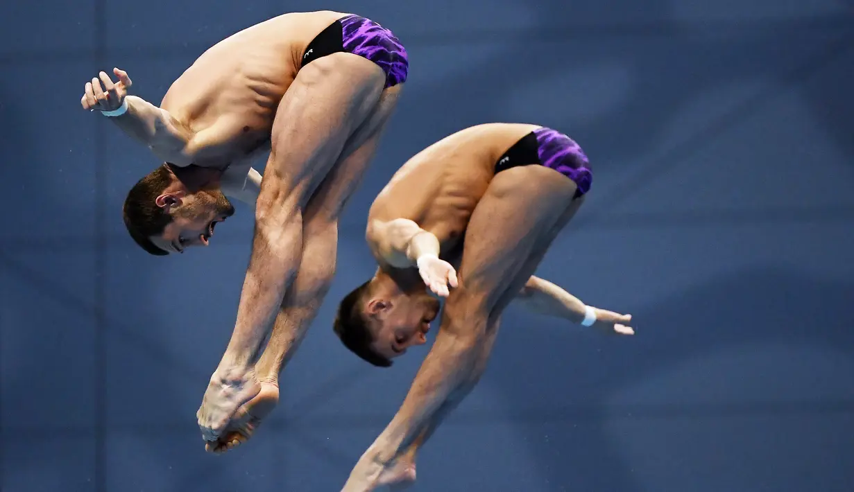 Perenang Rusia, Aleksandr Bondar dan Viktor Minibaev saat beraksi di nomor lompat indah sinkronisasi pada ajang Kejuaraan Akuatik Eropa di Duna Arena, Budapest, Hungaria, (15/5/2021). (AFP/Attila Kisbendek)