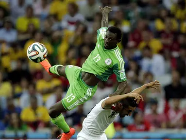 Juwon Oshaniwa (kiri) mencoba merebut bola atas dari Reza Ghoochannejhad (Iran) di babak penyisihan Piala Dunia Grup F, Baixada Arena, Brasil, (17/6/2014). (REUTERS/Henry Romero)