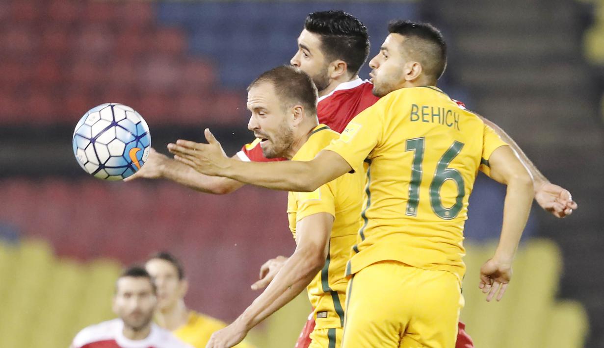 Pemain Australia, Aziz Behich, duel udara dengan pemain Suriah Omar Alsoma pada laga Kualifikasi Piala Dunia 2018 di Stadion Hang Jebat, Kamis (5/10/2017). Suriah bermain imbang 1-1 dengan Australia. (AP/Vincent Thian)