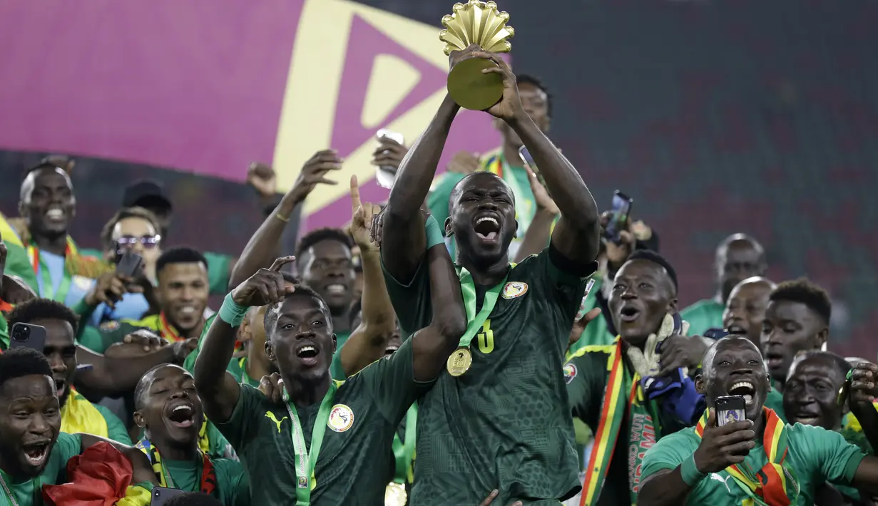 Para pemain Senegal merayakan dengan trofi setelah memenangkan pertandingan final Piala Afrika 2022 atas Mesir di Paul Biya Stadium, Kamerun, Senin (7/2/2022) dini hari WIB. Sadio Mane membawa Senegal mengalahkan Mesir lewat adu penalti dengan skor 4-2. (AP Photo/Sunday Alamba)