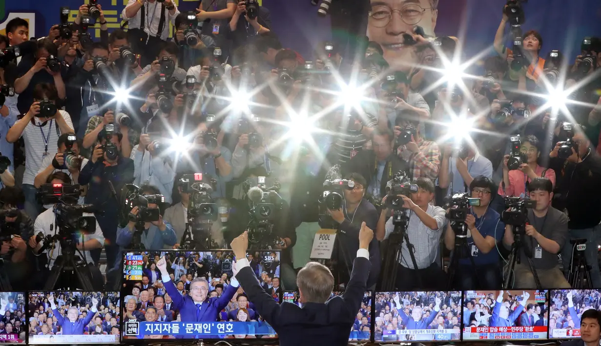 Kandidat Presiden Korsel, Moon Jae-in mengangkat tangan usai hasil hitung cepat memperlihatkan dia unggul dibanding calon lainnya di Seoul, Selasa (9/5). Calon Partai Demokrat itu menang telak dengan mengantongi 41,4 persen suara. (AP Photo/Lee Jin-man)