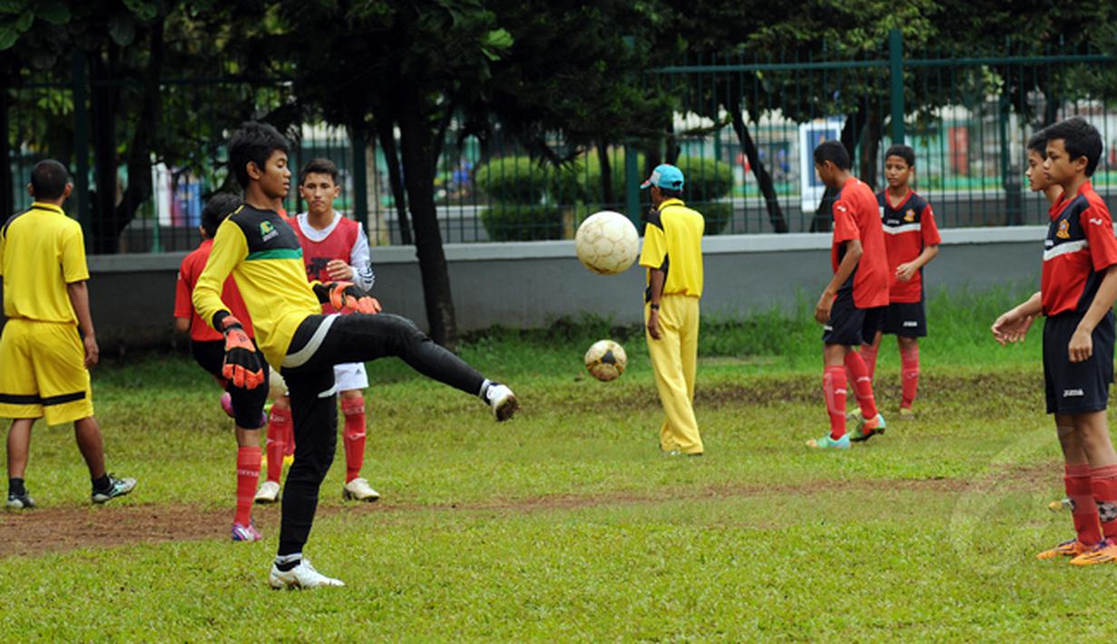 Beberapa anak berlatih teknik pengoperan bola di Sekolah Sepak Bola (SSB) ASIOP Apacinti di Lapangan A Senayan, Jakarta, Jumat (20/2/2015). (Liputan6.com/Helmi Fithriansyah)